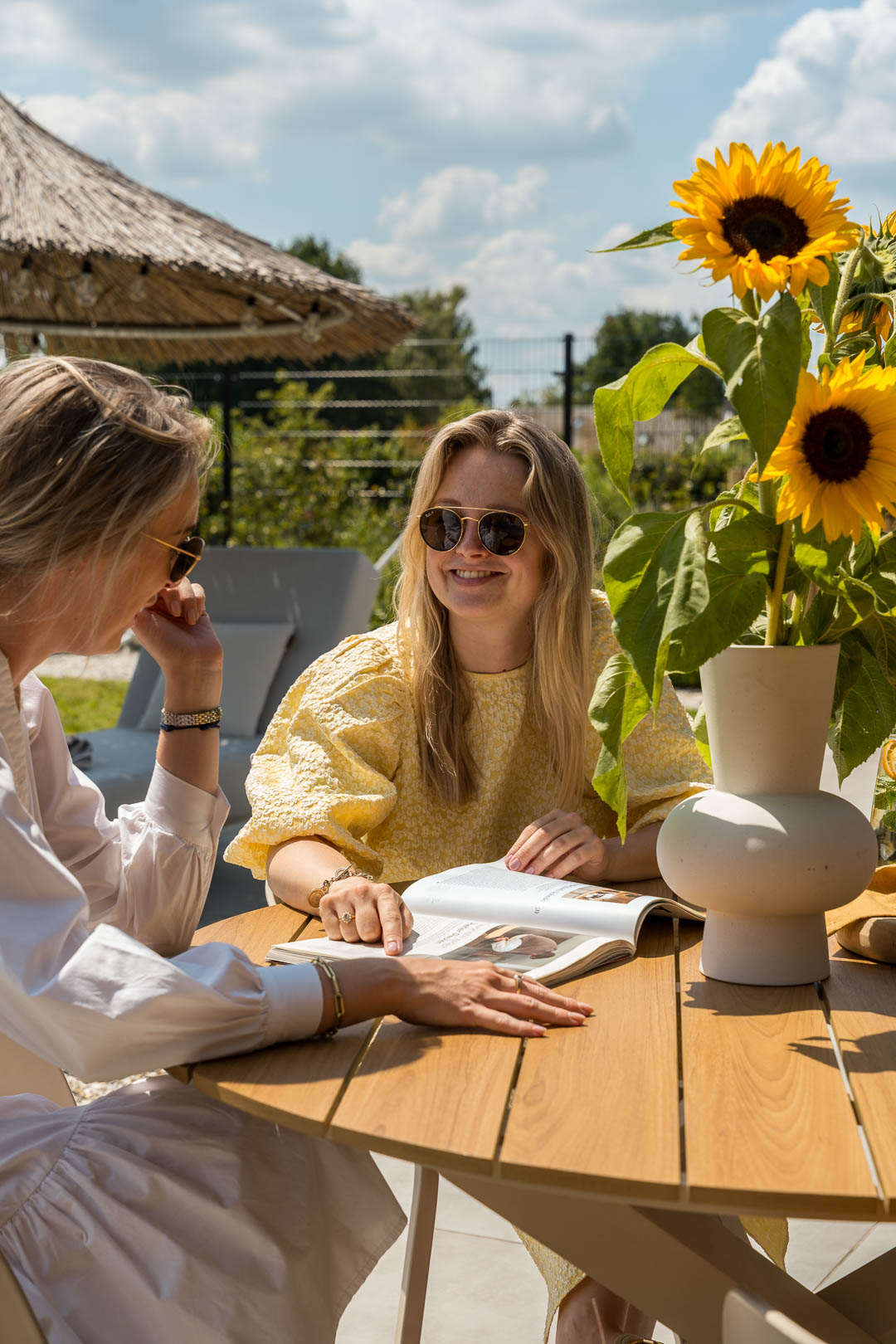 Mensen zitten samen aan een tuintafel in een moderne tuin